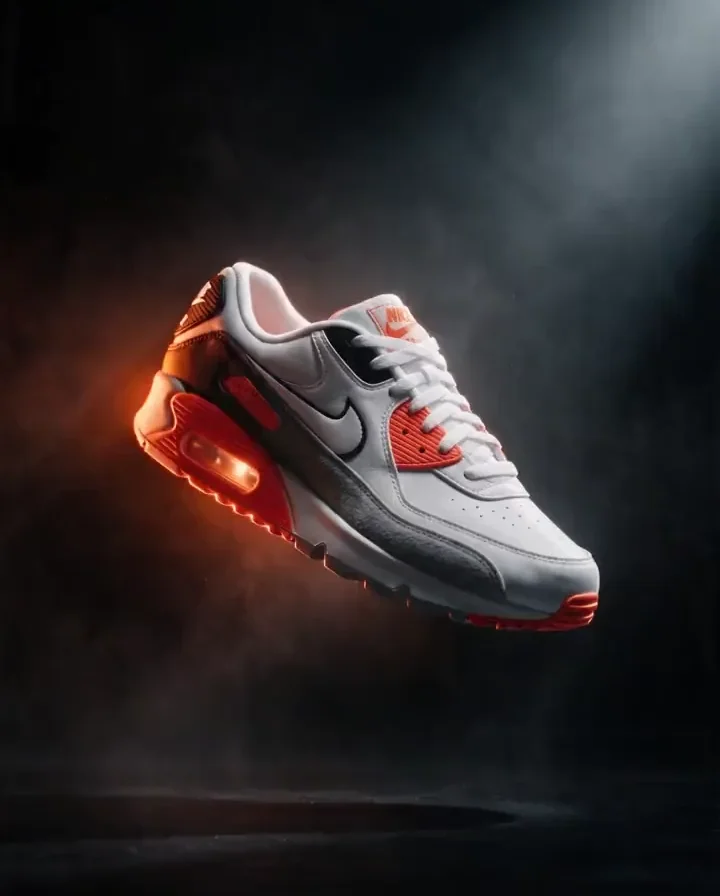 After: the same Nike Air Max 90 sneakers floating in a black studio with an orange backlight · AI-made spec piece